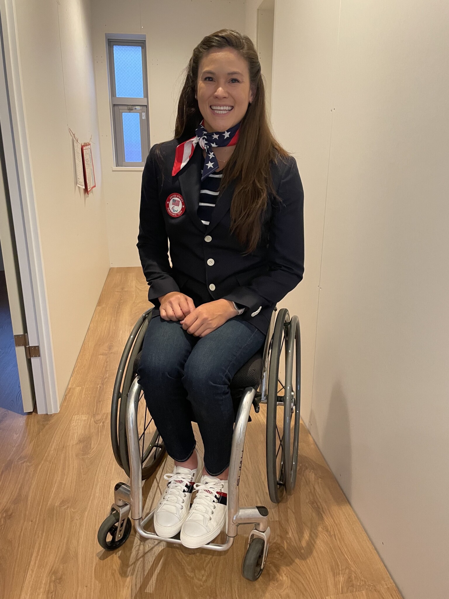 Wheelchair tennis player Dana Mathewson sits in a hallway in a Team USA uniform.
